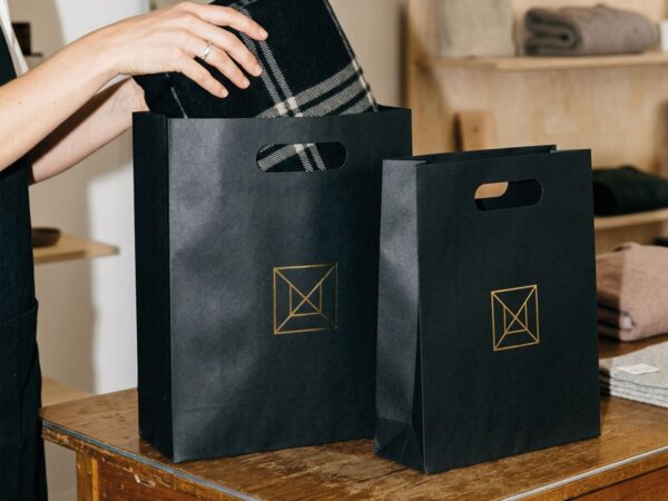 Svart Lyxpåse med guldprägling med stansade handtag | Egen design & tryck - Enklapack.se